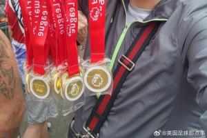 球迷在阿森納冠軍巡游賣獎(jiǎng)牌，撕開貼紙寫著：利物浦是冠軍！